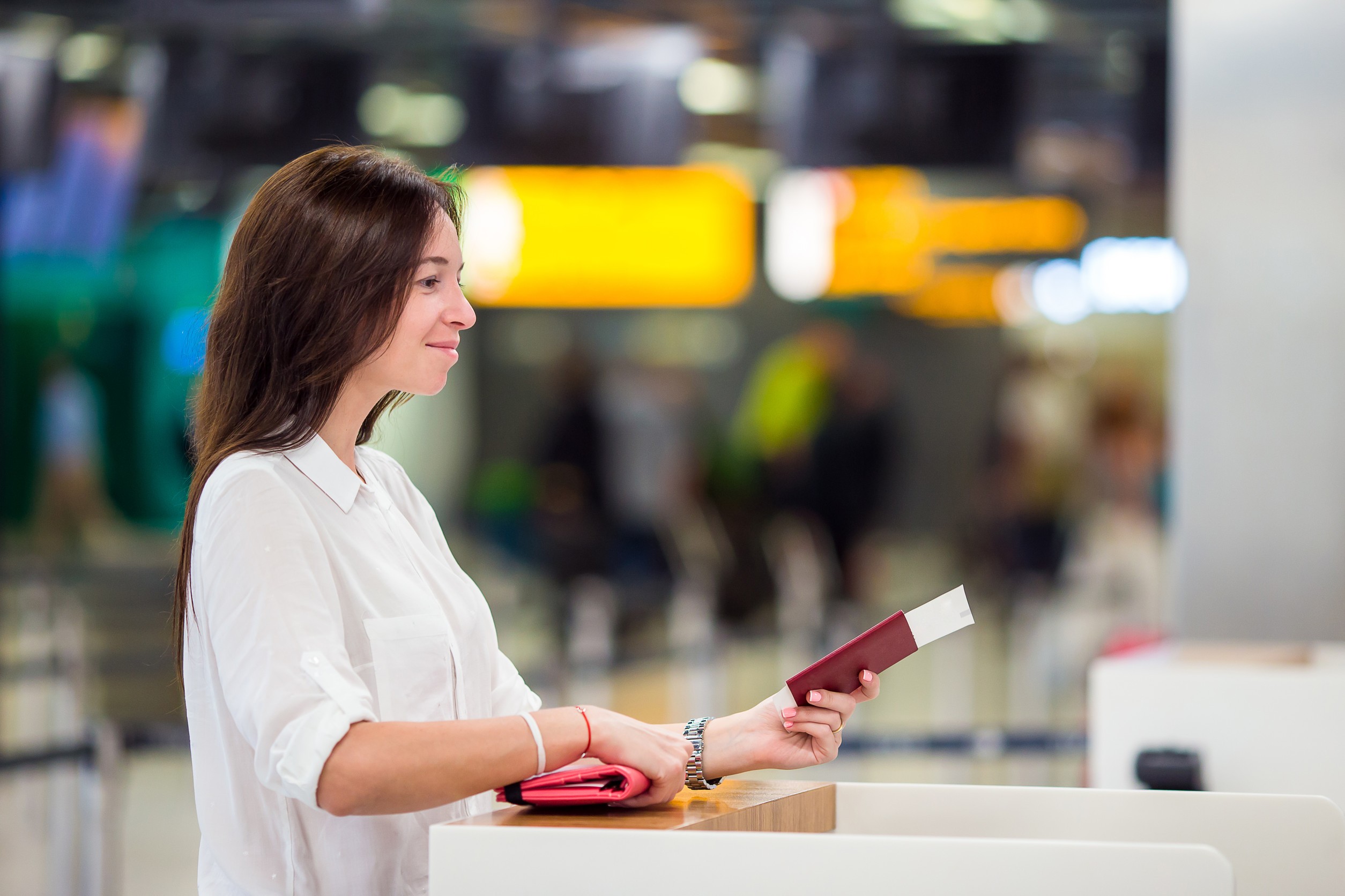 Happy Woman with Air Ticket at Airport Waiting for Flight